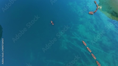 Lago Di Braies, Italy Aerial Cove Scene With Curved Boats Forming Semicircle Near Shallow Inlet, Clear Emerald Water, Distant Pine Cliffs And Cinematic Coastal Perspective