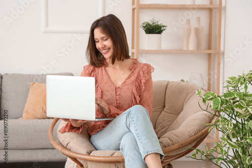 Young woman using laptop in...