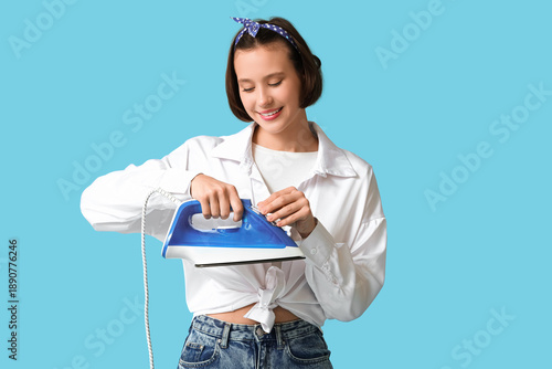 Young woman holding iron on...
