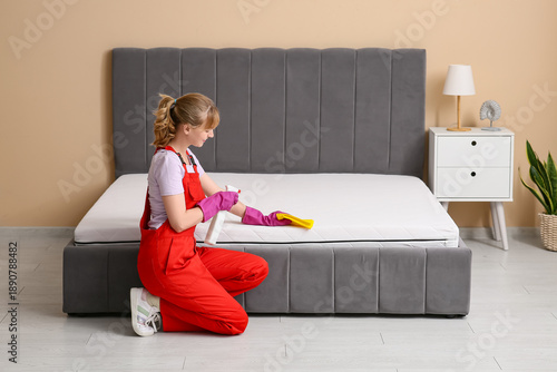 Female janitor cleaning mat...
