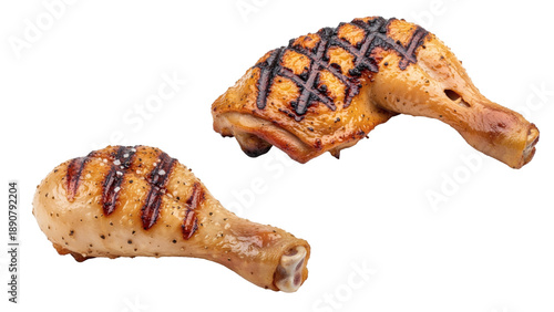 Close-up studio shot of two grilled chicken leg quarters, one whole, the other in pieces, against a black background