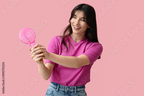 Young woman with mini fan o...