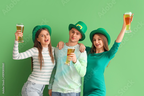 Young people with beer on green background. St. Patrick's Day celebration