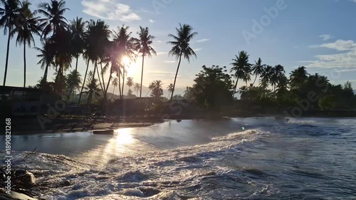 Beautiful morning at the beach with gentle waves and golden yellow sunlight, serene coastal landscape with cool refreshing atmosphere at dawn, scenic seascape during sunrise, tropical summer vibes