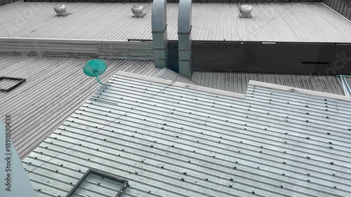 Textured of Corrugated Roofing Sheet, Dish Aerial, Chimney Ventilation System and Roof Ventilators spinning on Rooftop Record Video from Hotel at Bueng Kan, Thailand. 04NOV2025, A.M./ Real Time Video