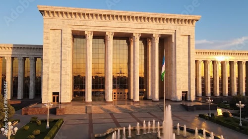Wallpaper Mural A grand, classical-style building with columns and large glass windows, a fountain in front Torontodigital.ca