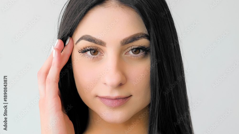 Naklejka premium Treatment beauty. Perfect skin. Young female touching soft face. Girl with long hair demonstrating natural makeup isolated on white.