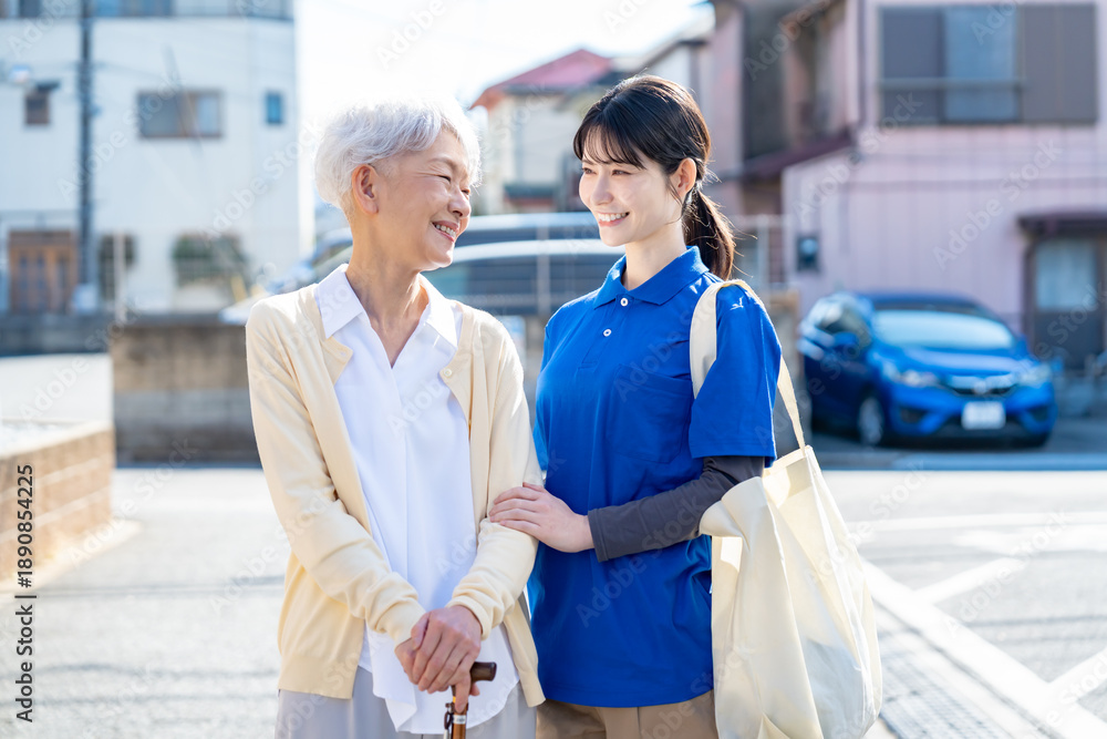 Obraz premium 高齢女性と介護・買い物代行スタッフの同行シーン／地域支援・生活サポート訴求