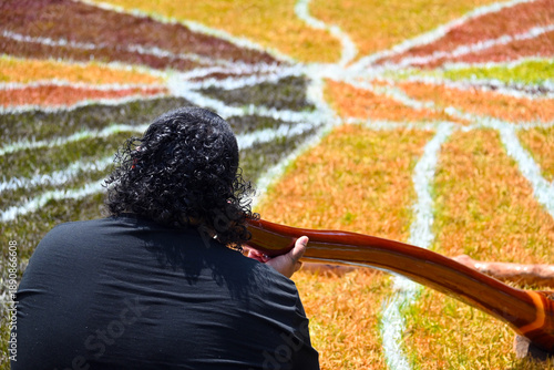 Fotografie Indigenous Australians man play Aboriginal music with didgeridoo wind instrument