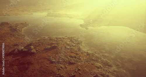 Bild auf Leinwand sunlit aerial coastline with golden haze and distant bay, warm backlight, gentle