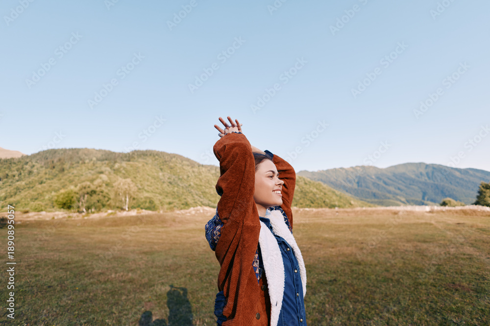 Fototapeta premium woman outdoor mountains field sweater portrait happy landscape with arms raised, smiling female enjoying fresh air in open meadow, casual autumn clothing under blue sky