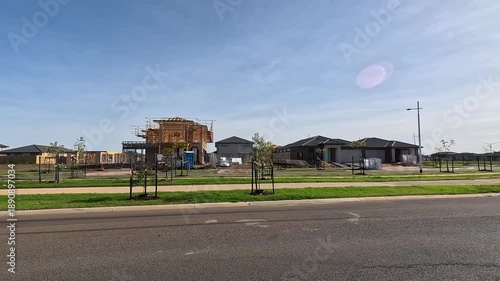 A new suburban estate in Tarneit, Melbourne, Australia, showing newly built houses, active construction sites, young street trees, and wide roads in a developing residential neighborhood.