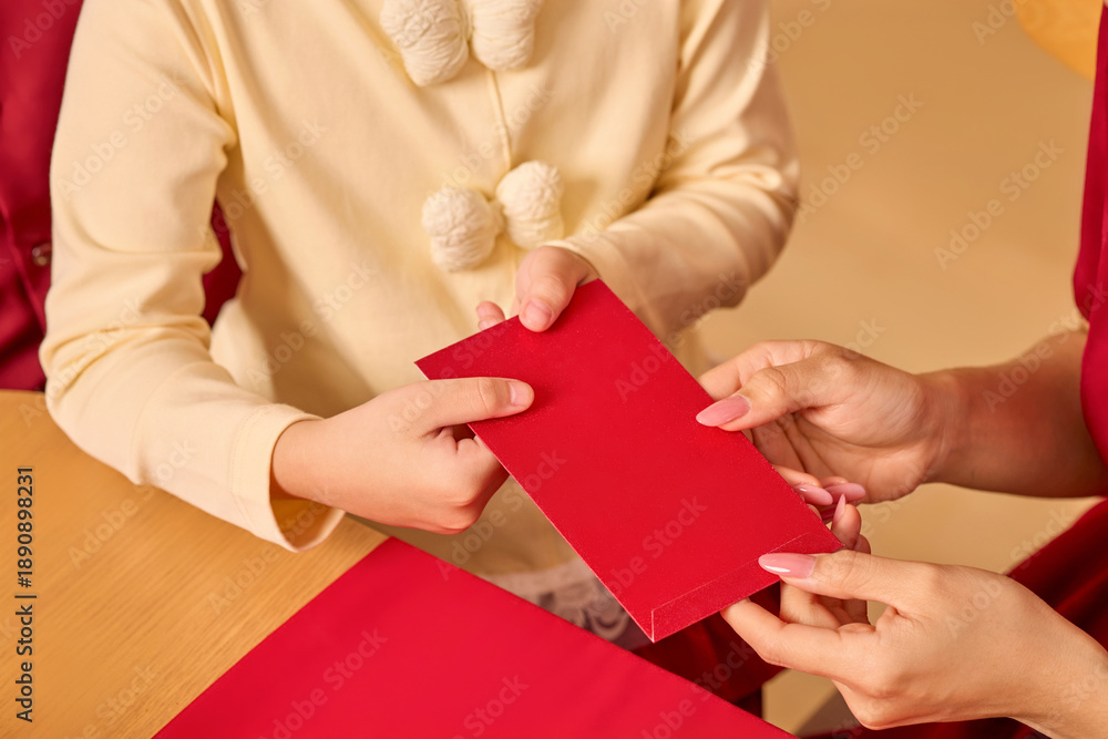 Obraz premium Close-up of hands passing a red envelope, symbolizing luck and tradition during an Asian New Year celebration