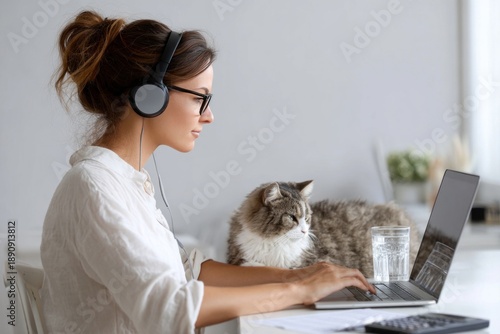Woman working remotely with cat companion © ЮРИЙ ПОЗДНИКОВ