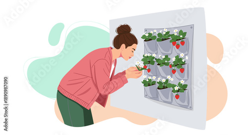 Woman tending to a vertical garden with strawberries and flowers.