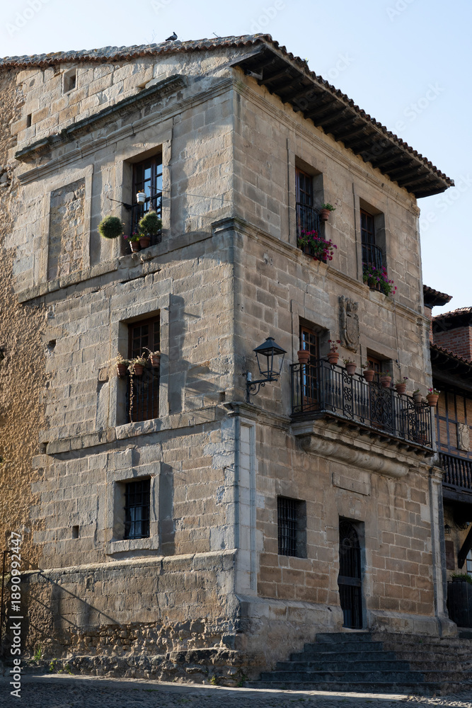 Fototapeta premium Historic stone building with balconies and flowers.. Santillana del Mar, Santander, Spain
