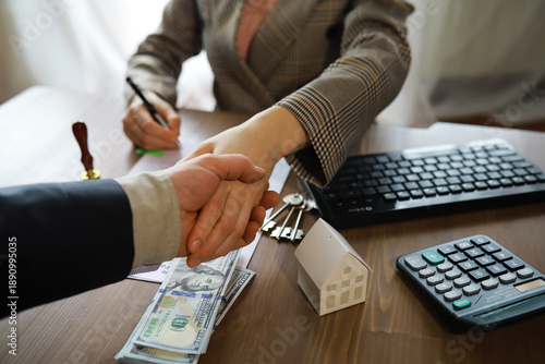 European businesswoman working in real estate company. She is giving cash money to male customer.