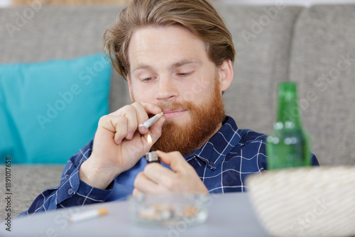 Photography stoned man lighting a joint in his home