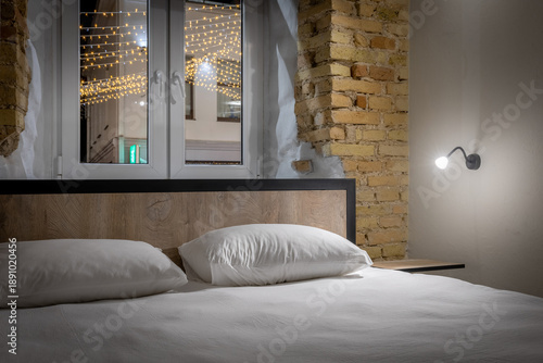 Bild auf Leinwand Double bed in a private loft hostel room with night city view