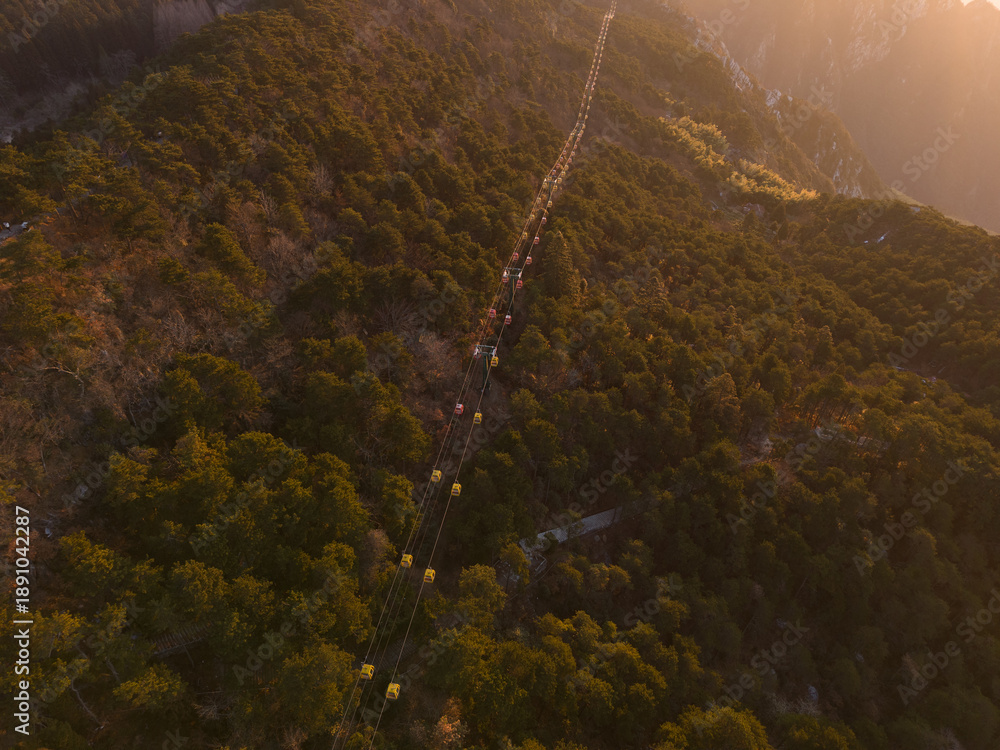 Fototapeta premium View of a long line of cable cars ascending a forested mountain in Lushan Mountain, Jiangxi, China