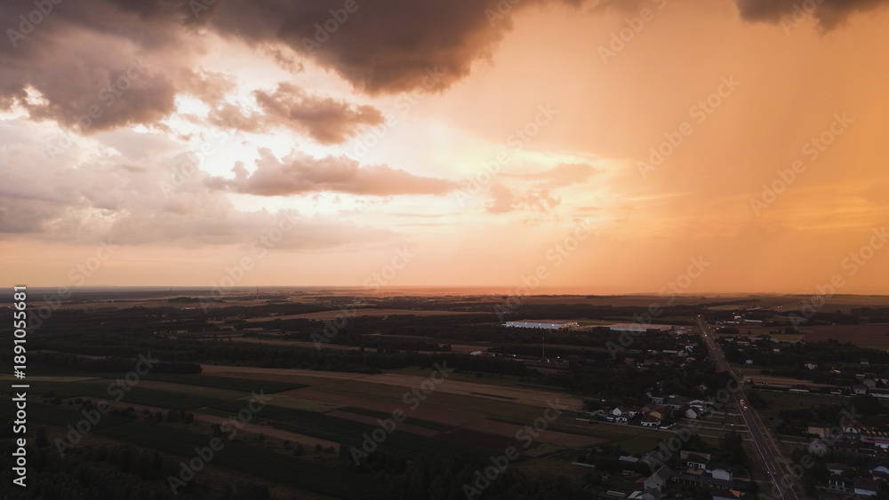 Fototapeta premium Dramatic sunset with heavy clouds over summer fields