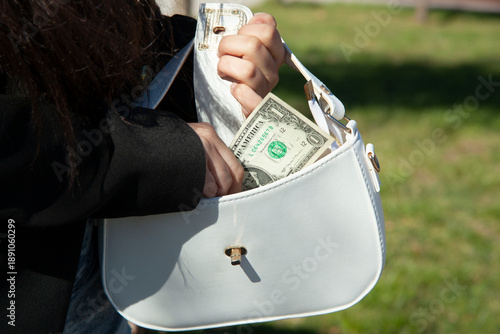 female hands hold dollar bills.