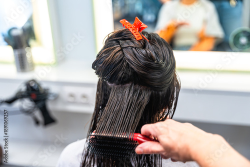 Foto Hairdresser styling wet hair of a woman in salon