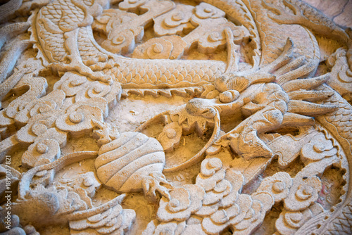 Fényképezés Carved Stone Dragon Relief with Traditional Asian Ornamental Details