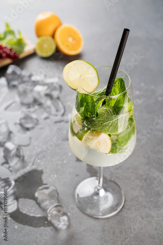 Photos Refreshing Lime Mint Sparkling Water with Ice in Elegant Wine Glass on Gray Back