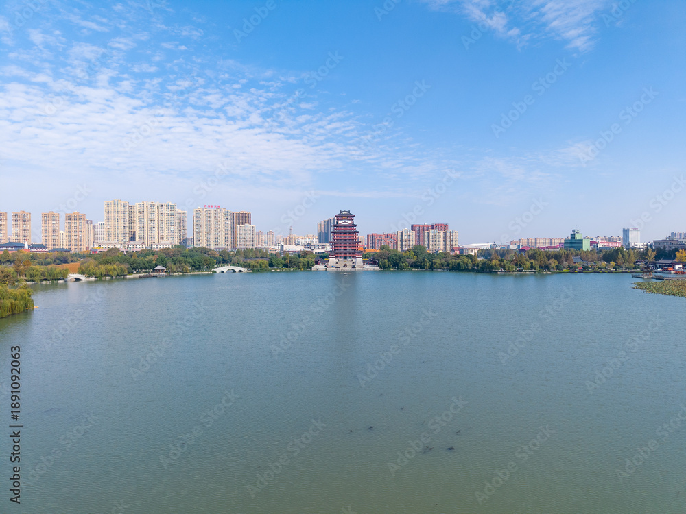 Obraz premium Aerial view of a lake with buildings and a pagoda in Tianmen City, Hubei Province