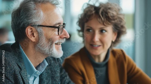 Happy middle aged professionals enjoying each others company in a bright urban cafe while discussing projects and sharing laughs during a busy workday