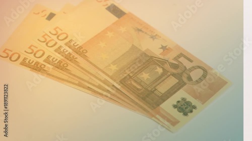 Animation of close up of euro bills falling against yellow gradient background