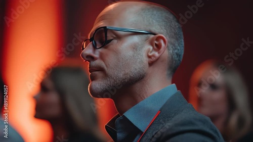 Engaged audience member listening intently during a corporate event focused on professional development and networking in a dimly lit venue