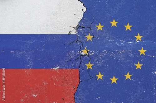 flag of Russia and the flag of the European Union on the old damaged wall