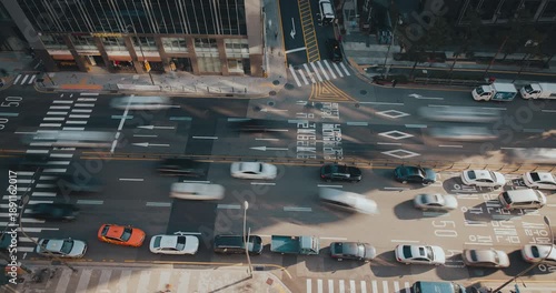 A vibrant urban street captures the continuous flow of vehicles moving through intersections, emphasizing the rhythm of city traffic. Time-lapse, Seoul, South Korea