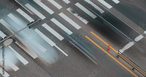 Vehicles move through a bustling urban crosswalk, highlighting the dynamic flow of traffic and the interaction of cars with road markings. Time-lapse, Seoul, South Korea