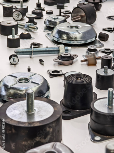Metal and rubber parts are arranged on a table for sorting in a workshop during the day