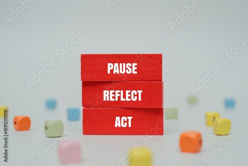Fotografie A coloured blocks with text PAUSE, REFLECT, ACT surrounded by colorful beads