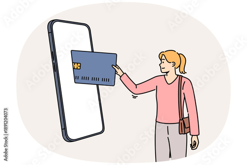 Woman mobile banking user inserts credit card into large phone to make purchase in online store. Concept of online payment for goods on website or application thanks to digital banking