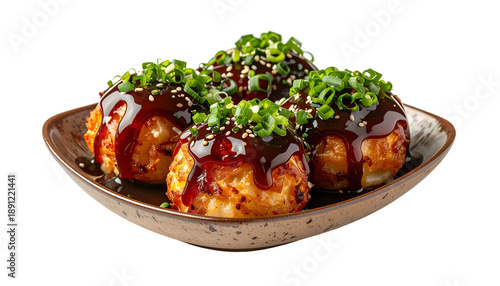 Savory Japanese dish of grilled balls, drizzled with sauce, topped with greens, served on a plate