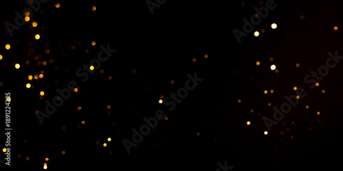 Golden abstract bokeh on black background.