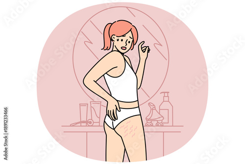 Woman sees cellulite on butt and thighs standing near mirror, and needs consult trainer to combat excess weight. Cellulite causes fear in girls, want to lose weight or improve own body