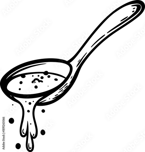 Wooden spoon pouring liquid sauce or soup with splashes and seasoning particles