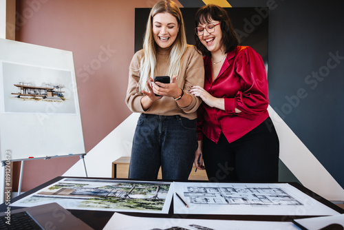 Принти на полотні Two young women discussing architectural creativity and sharing ideas with enthu