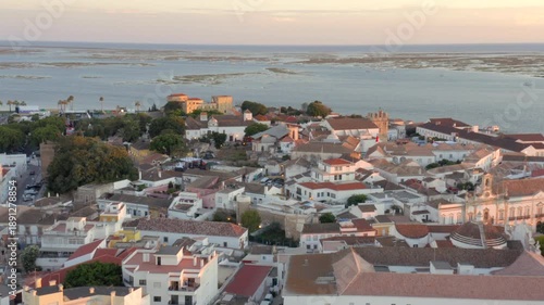 Faro Portugal drone backward reveal of Old Town at golden hour aerial