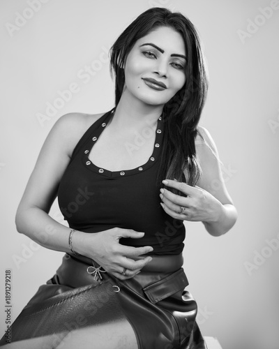 High-quality black and white studio portrait of a stylish confident woman posing gracefully with a soft relaxed expression against a neutral background. Beauty, glamour, fashion and lifestyle concept 