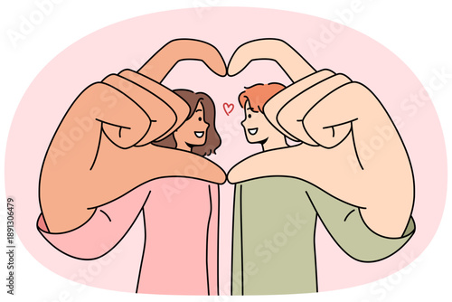 Romantic couple shows symbol of love and devotion, giving heart from hands and wanting to kiss. Multinational man and woman are proud of mutual love or opportunity to build united family