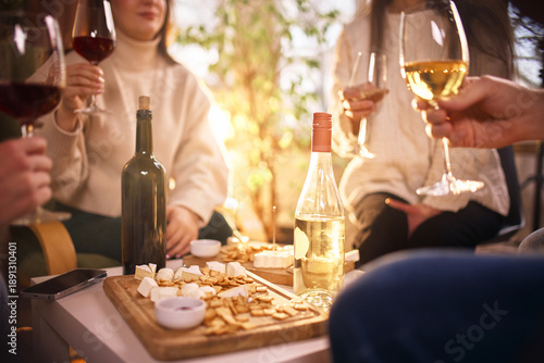 Billede på lærred Wine tasting table with snacks and people socializing indoors