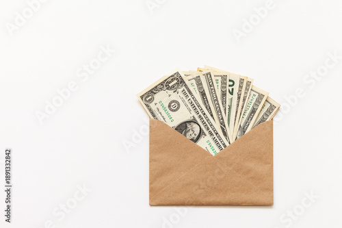 American dollars in paper envelope on white background. This could be bribe to an official; family savings; 