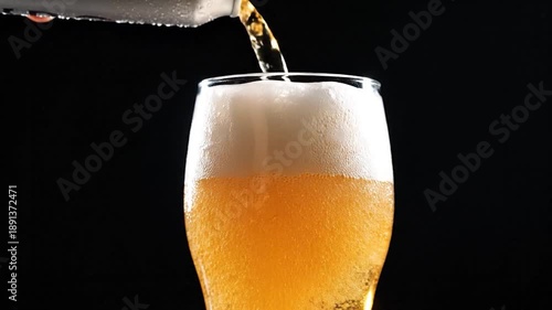 Wallpaper Mural Close-up of beer being poured into a glass with white foam against a black background Torontodigital.ca